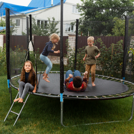 kids playing on the trampoline with an adult
